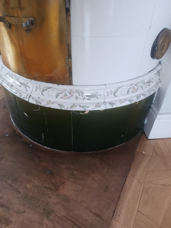 Vit rund kakelugn med blommor