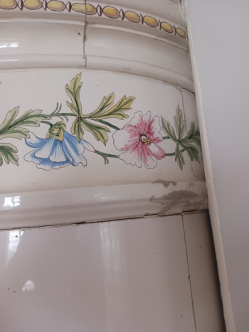 Vit rund kakelugn med blommor